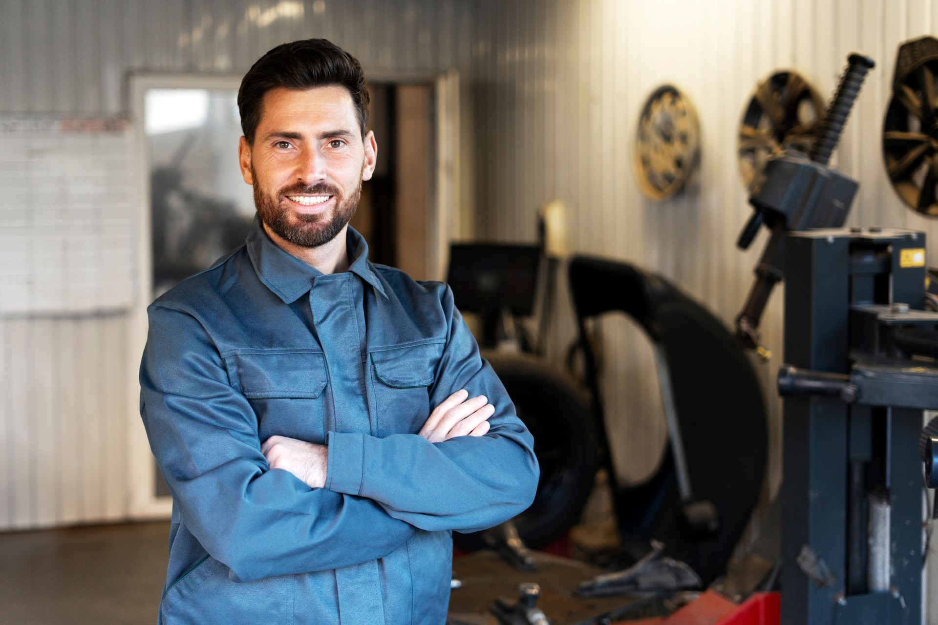 Mechanic smiling with crossed arms in auto repair shop